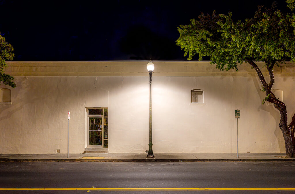 Filamento Post Top VA6 Lamp installed in a street lamp in front of a wall in the city of Vacaville